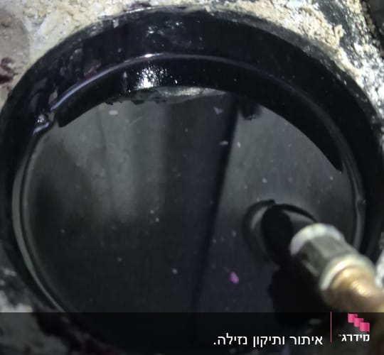 צינור מחובר לפתח עגול עם נוזל כהה